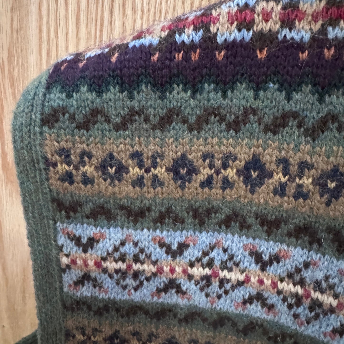 Close-up of a knitted fabric with a pattern on a wooden surface