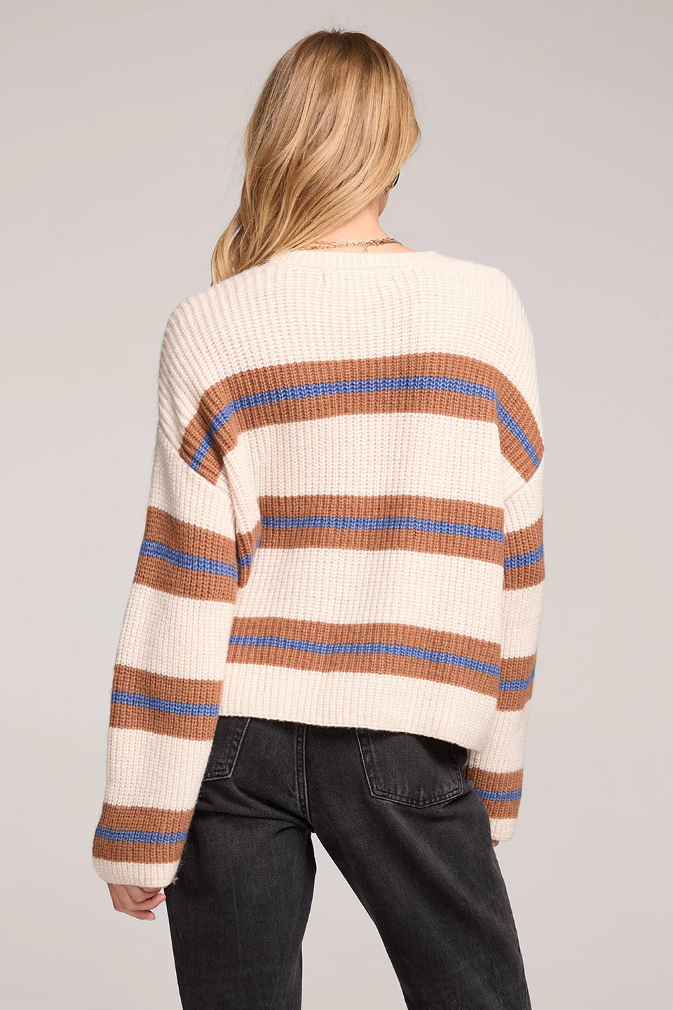 Woman wearing a striped sweater with a neutral background