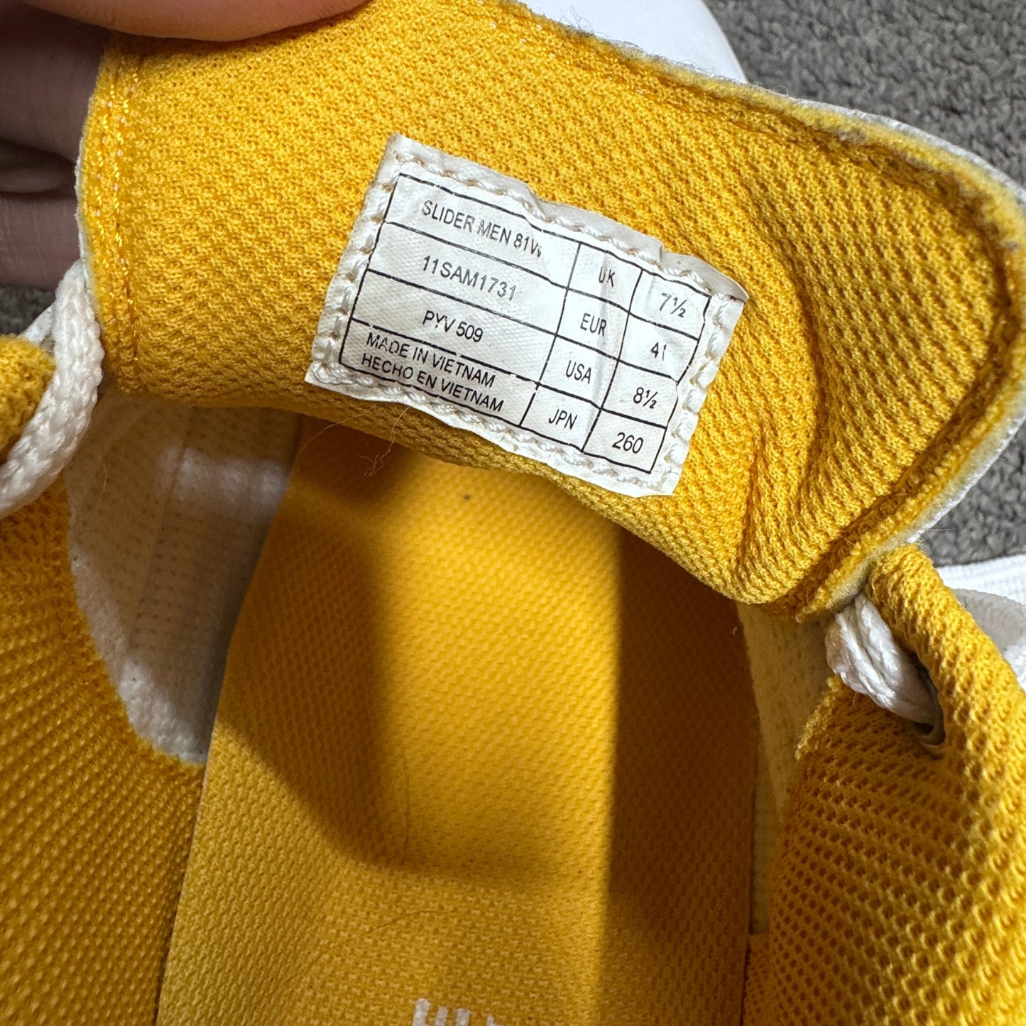 Yellow shoe with a size label on a textured surface