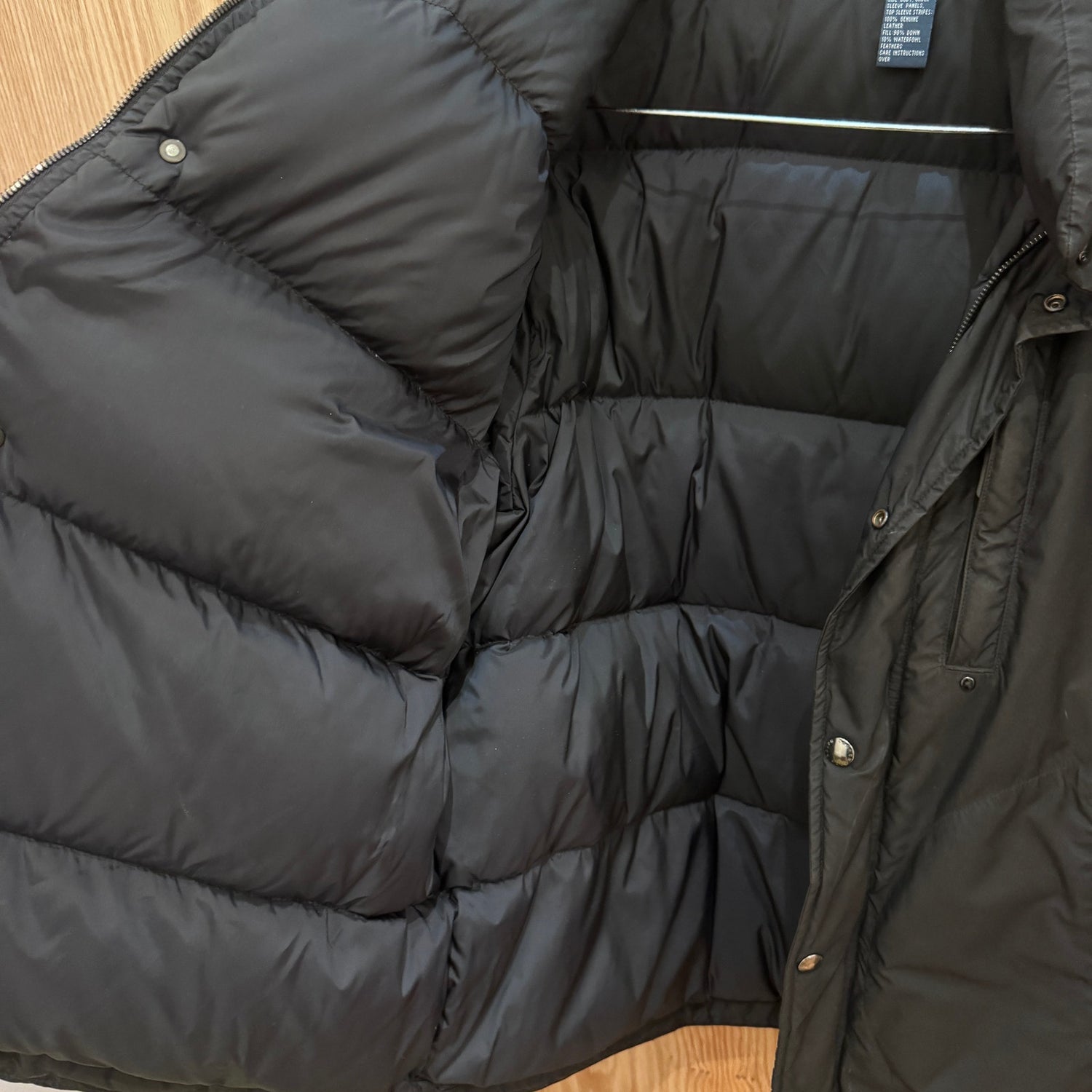 Black puffer jacket on a wooden surface