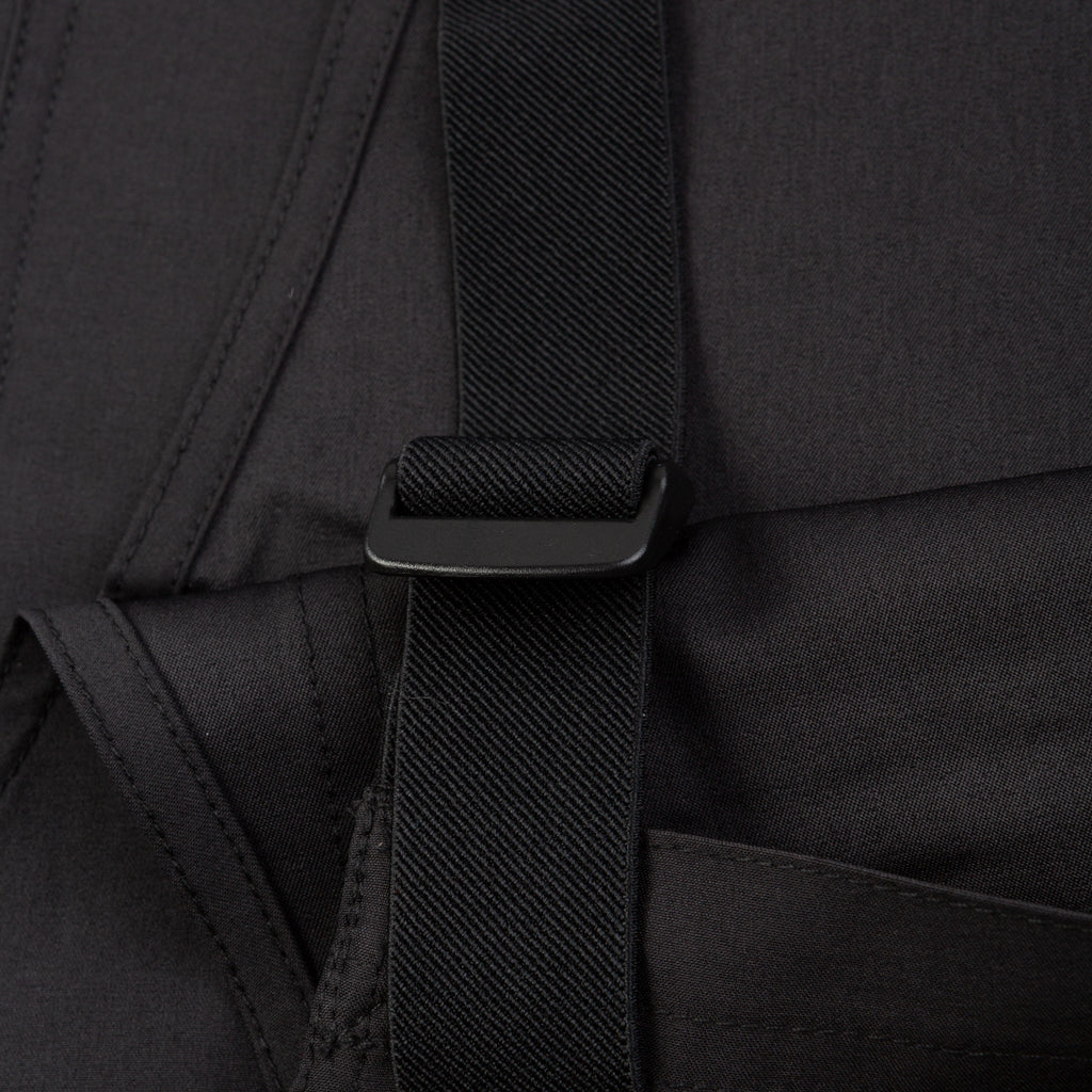 Close-up of a black backpack strap on a dark background