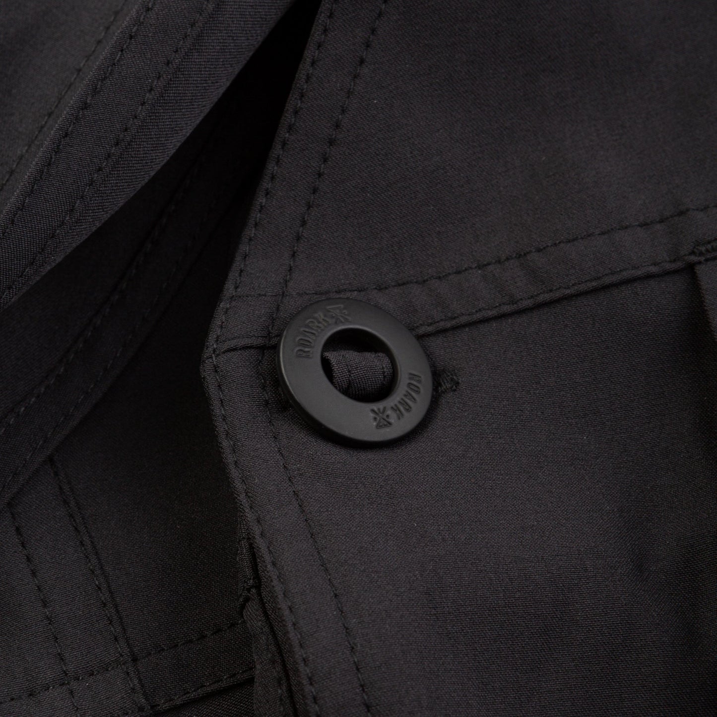 Close-up of a black button on a black fabric background