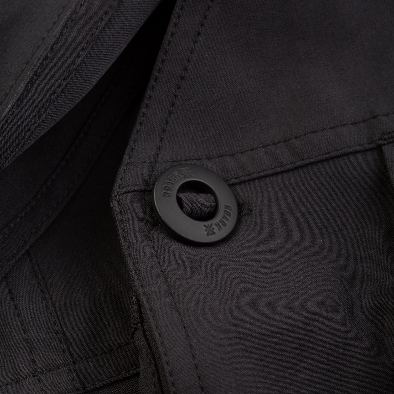 Close-up of a black button on a black fabric background