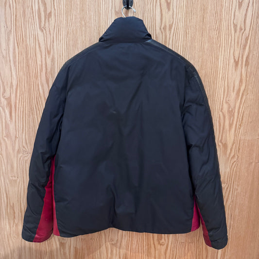 Black jacket with red lining on a wooden surface