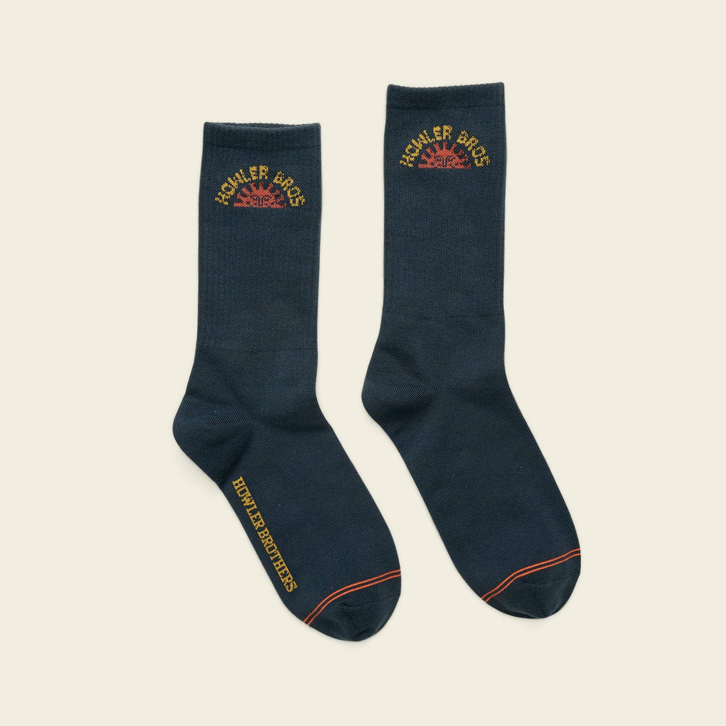 Pair of navy blue socks with embroidered logo on a beige background