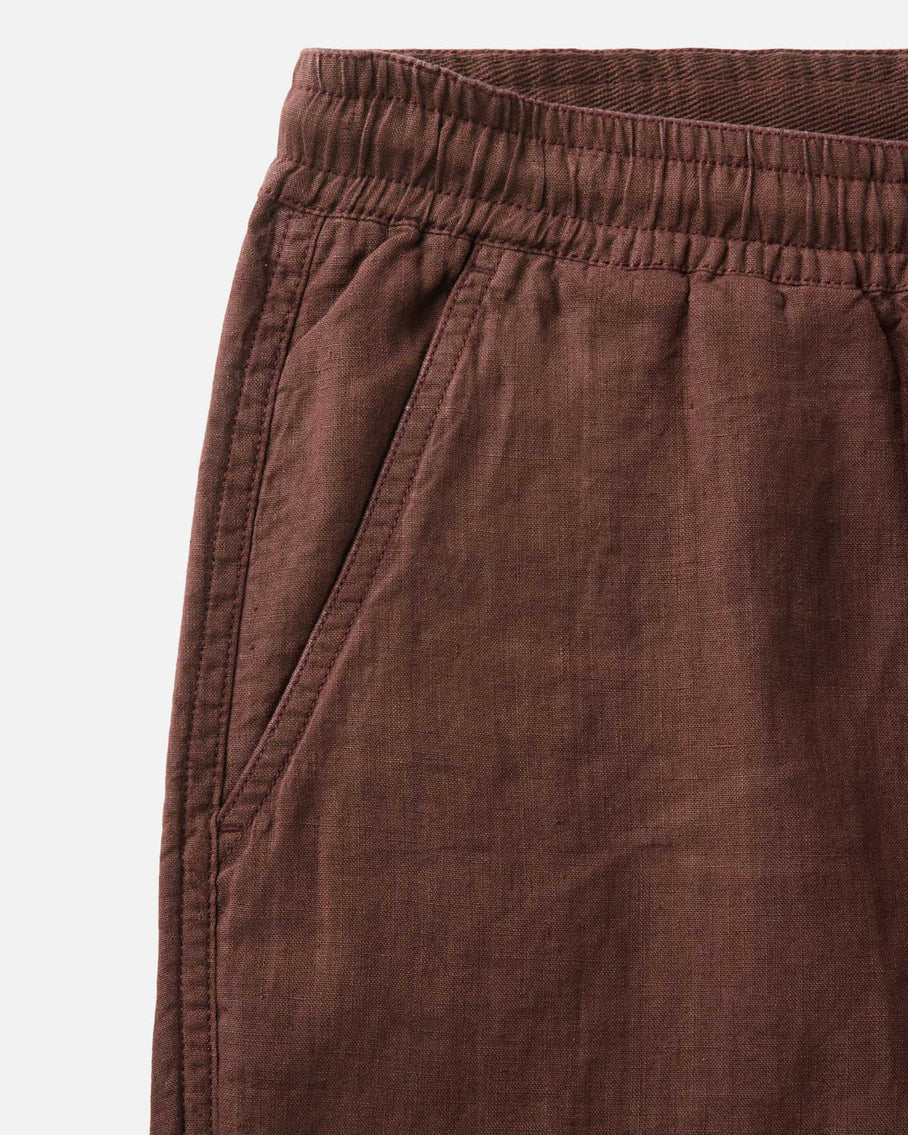 Close-up of brown pants with an elastic waistband on a light gray background