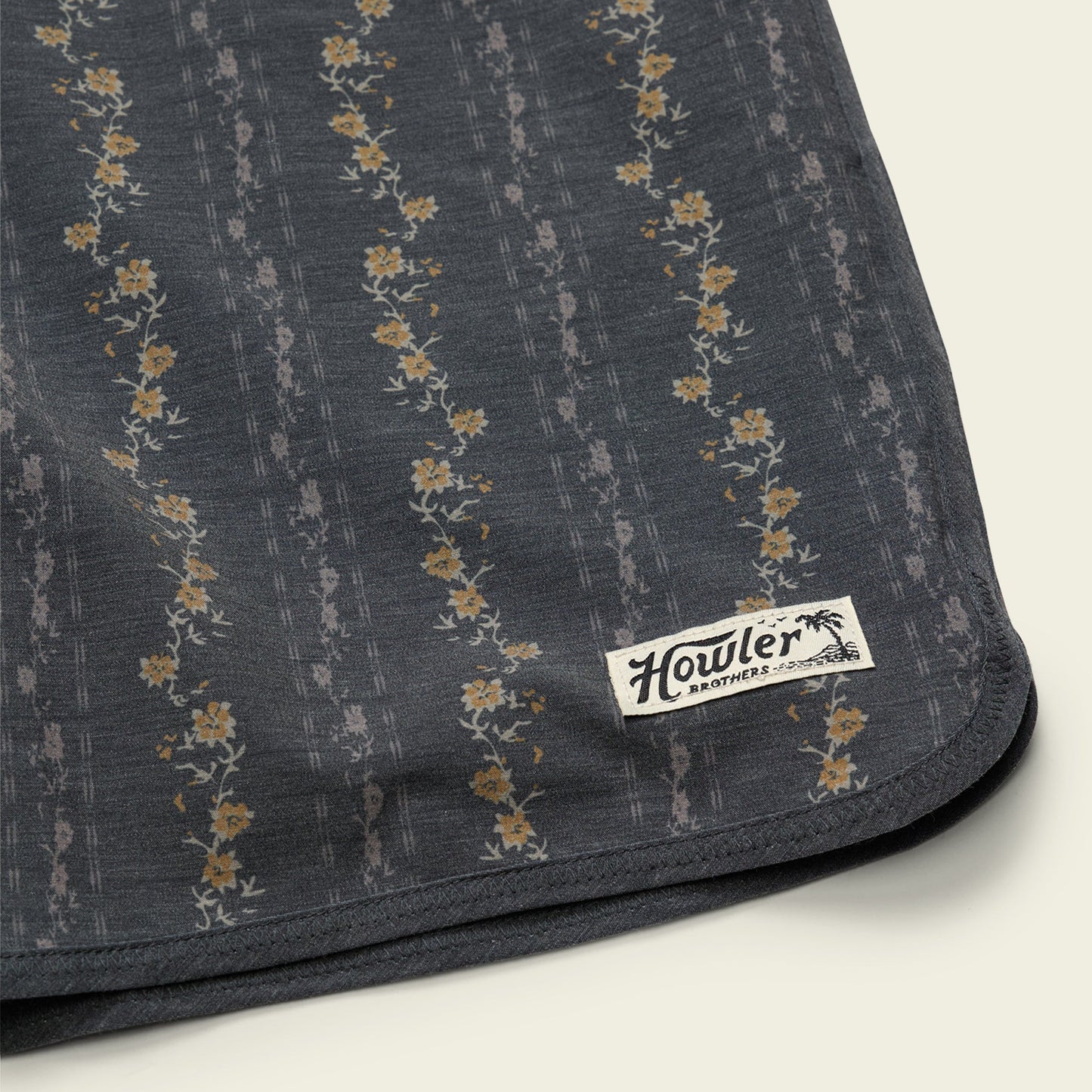 Dark fabric with floral pattern and Howler Brothers label on a light background