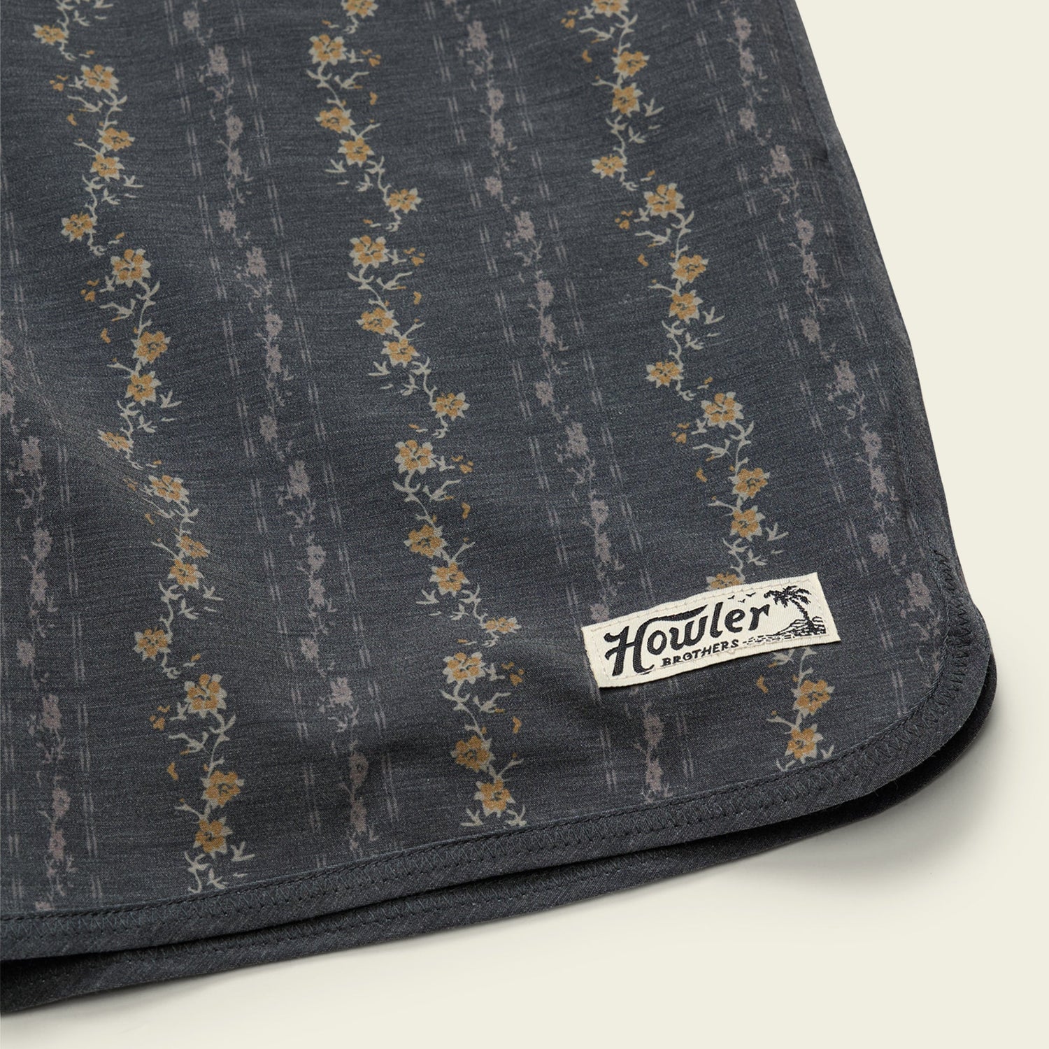Dark fabric with floral pattern and Howler Brothers label on a light background