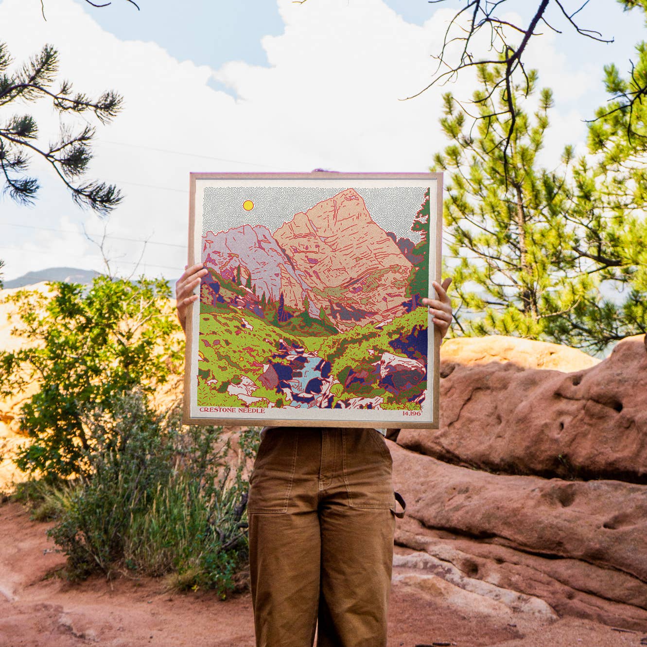 artist holder her print up out in nature colorado