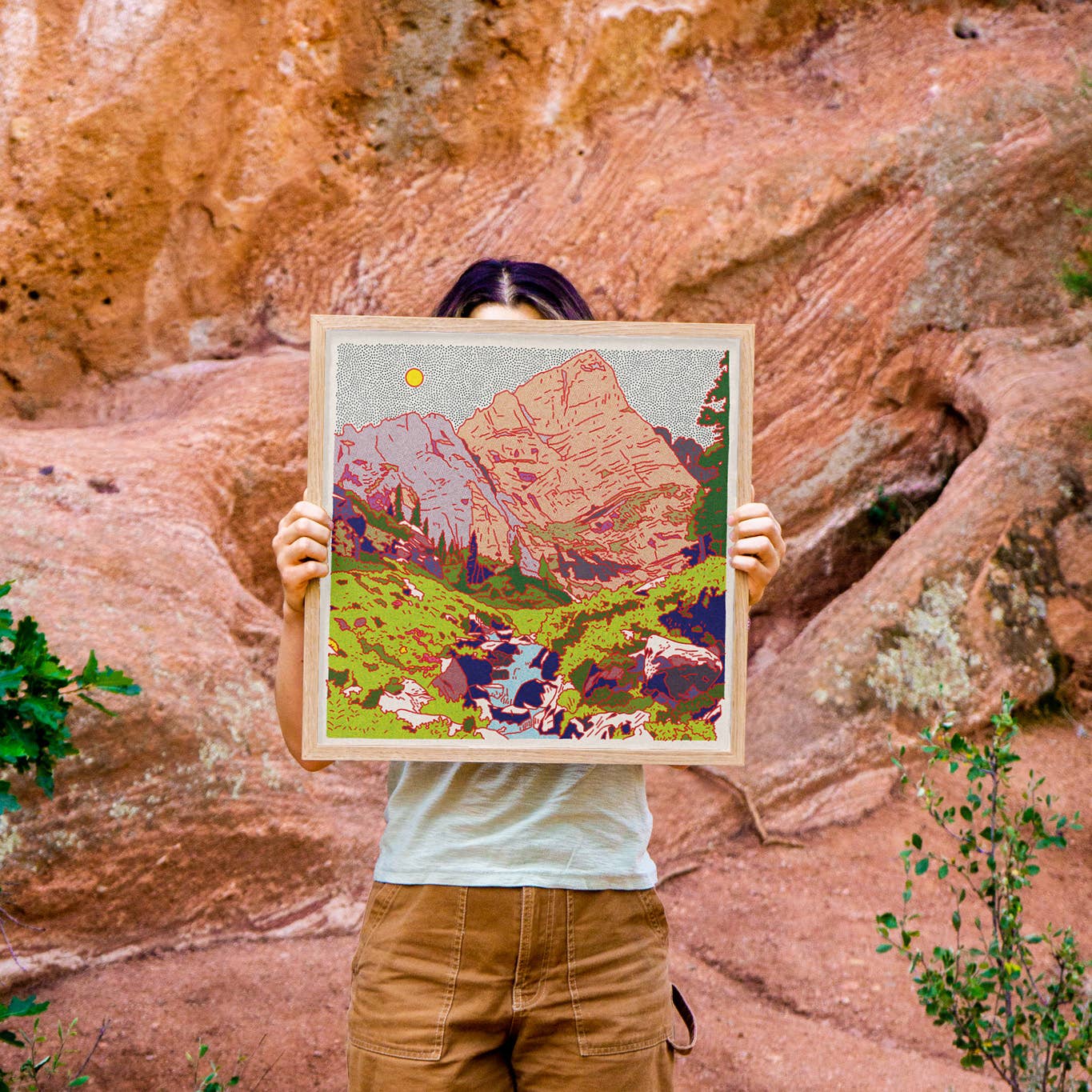 artist holding her art up out in nature