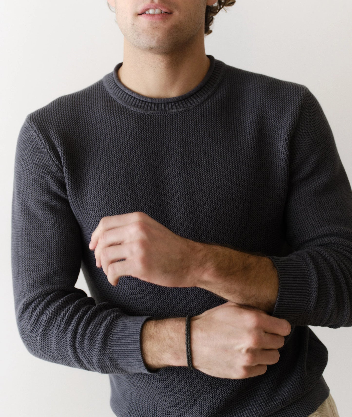 Man wearing a dark gray sweater against a plain background