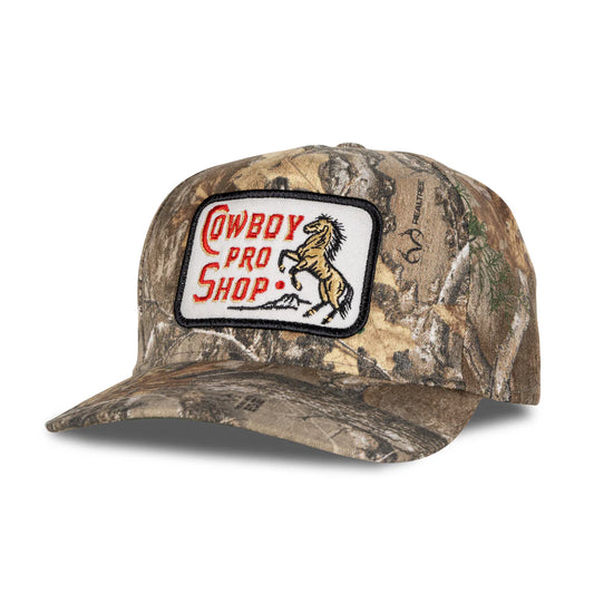 Camouflage cap with a 'Cowboy Pro Shop' patch on a white background