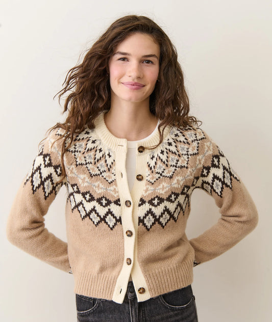 Woman wearing a patterned beige sweater with a plain background