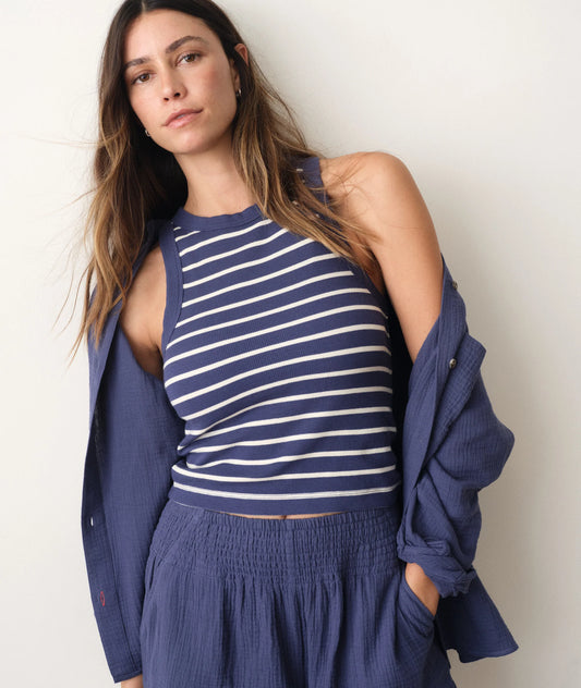 Woman wearing a blue and white striped top with a matching jacket against a plain background