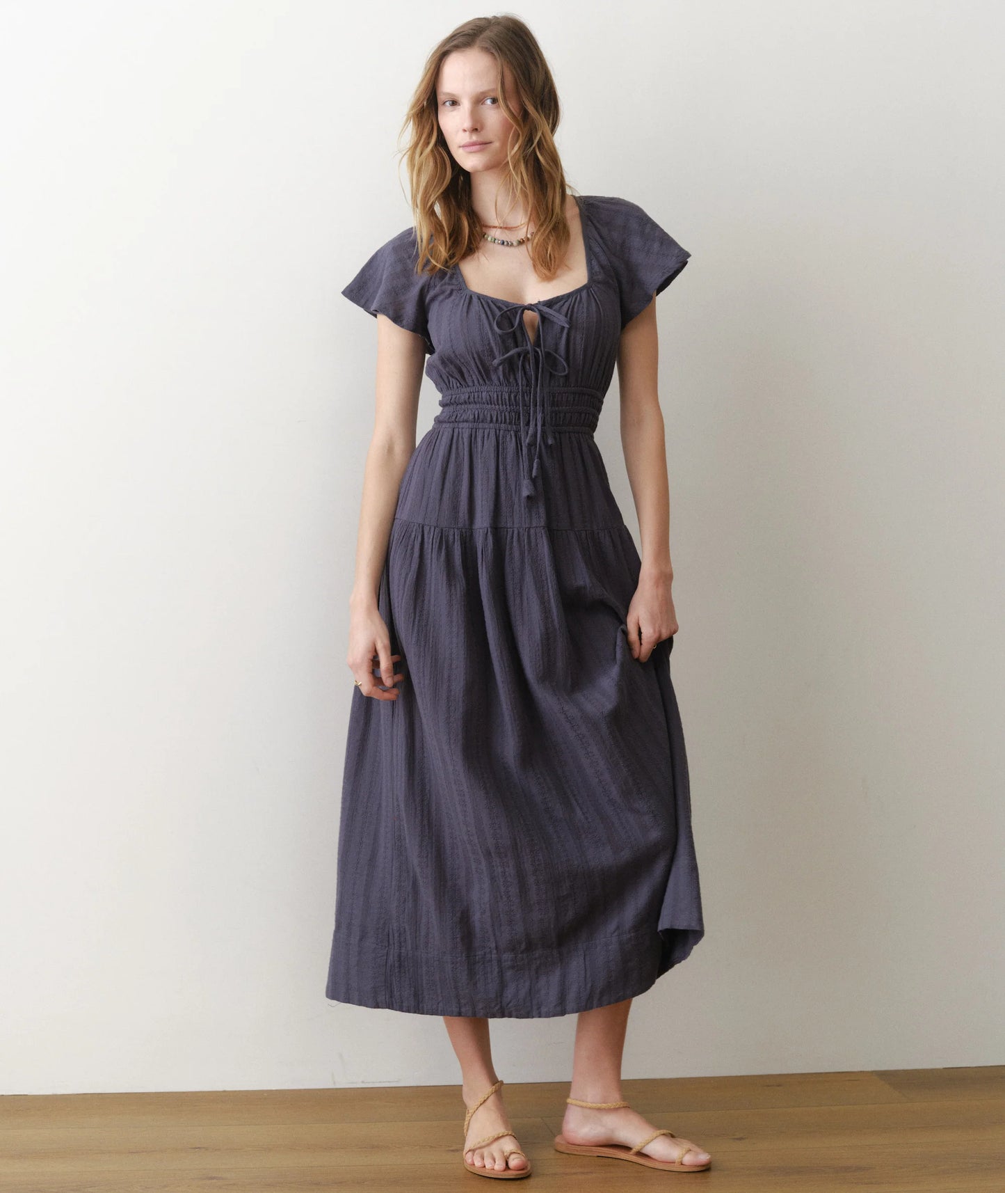 Woman wearing a dark blue dress against a plain background