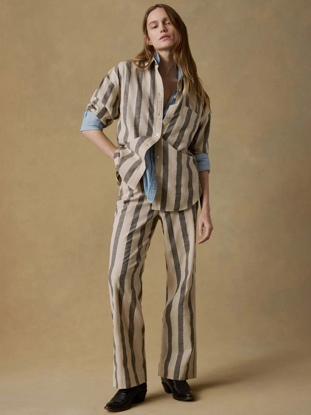 Person wearing a striped outfit against a beige background