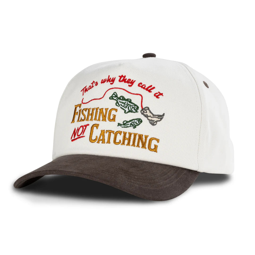 White cap with brown bill featuring fishing-themed text and graphics on a white background