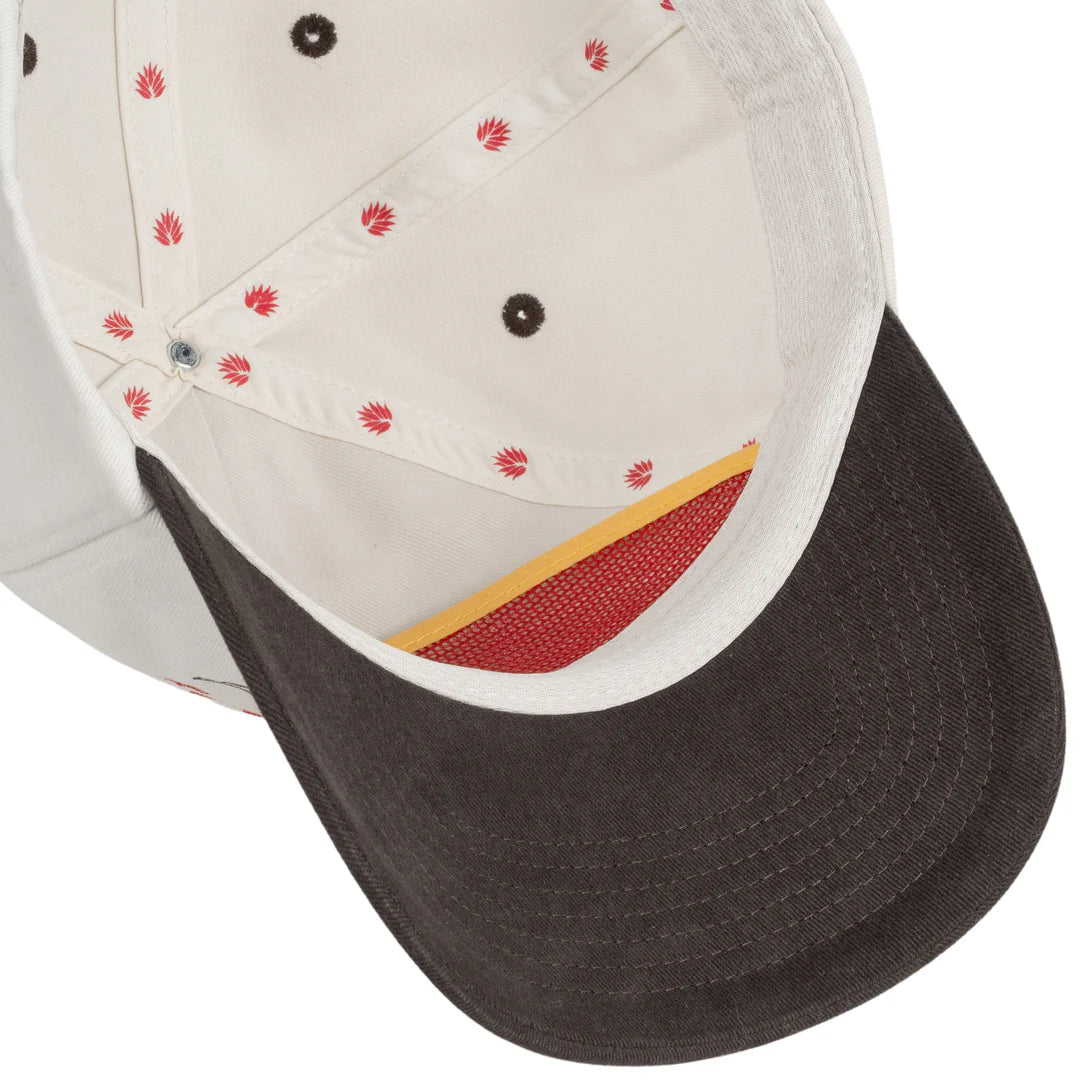 Close-up of a cap with a white front panel and black bill, featuring red floral patterns.