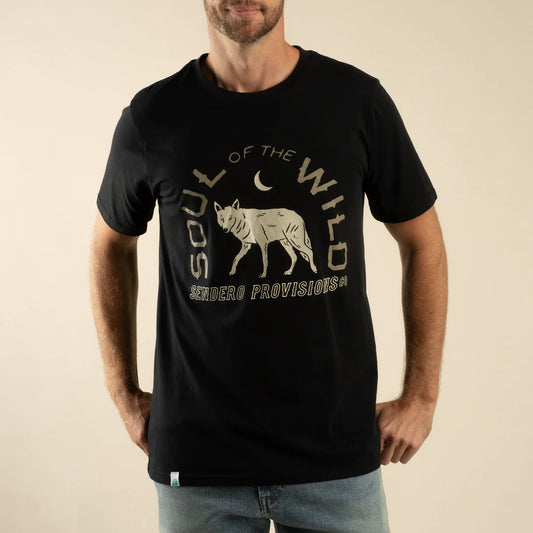Man wearing a black t-shirt with a wolf graphic and text on a beige background