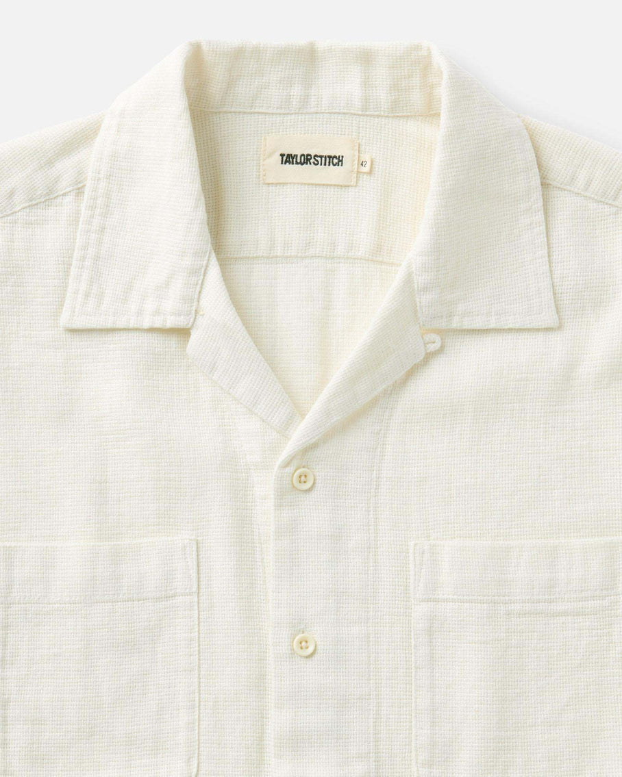 Close-up of a white shirt with a 'Taylor Stitch' label on a white background