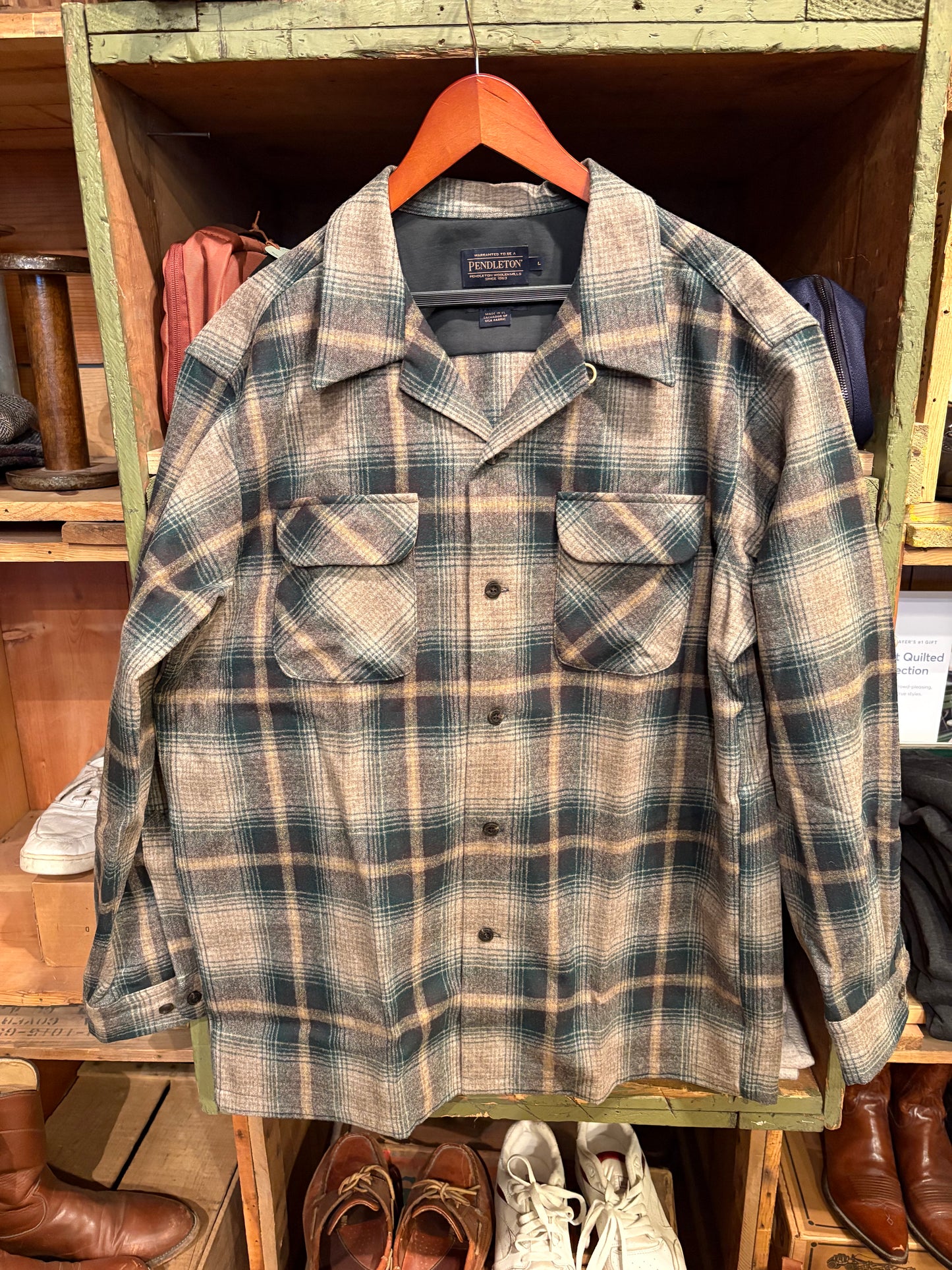 Plaid shirt hanging on a wooden rack with shoes below