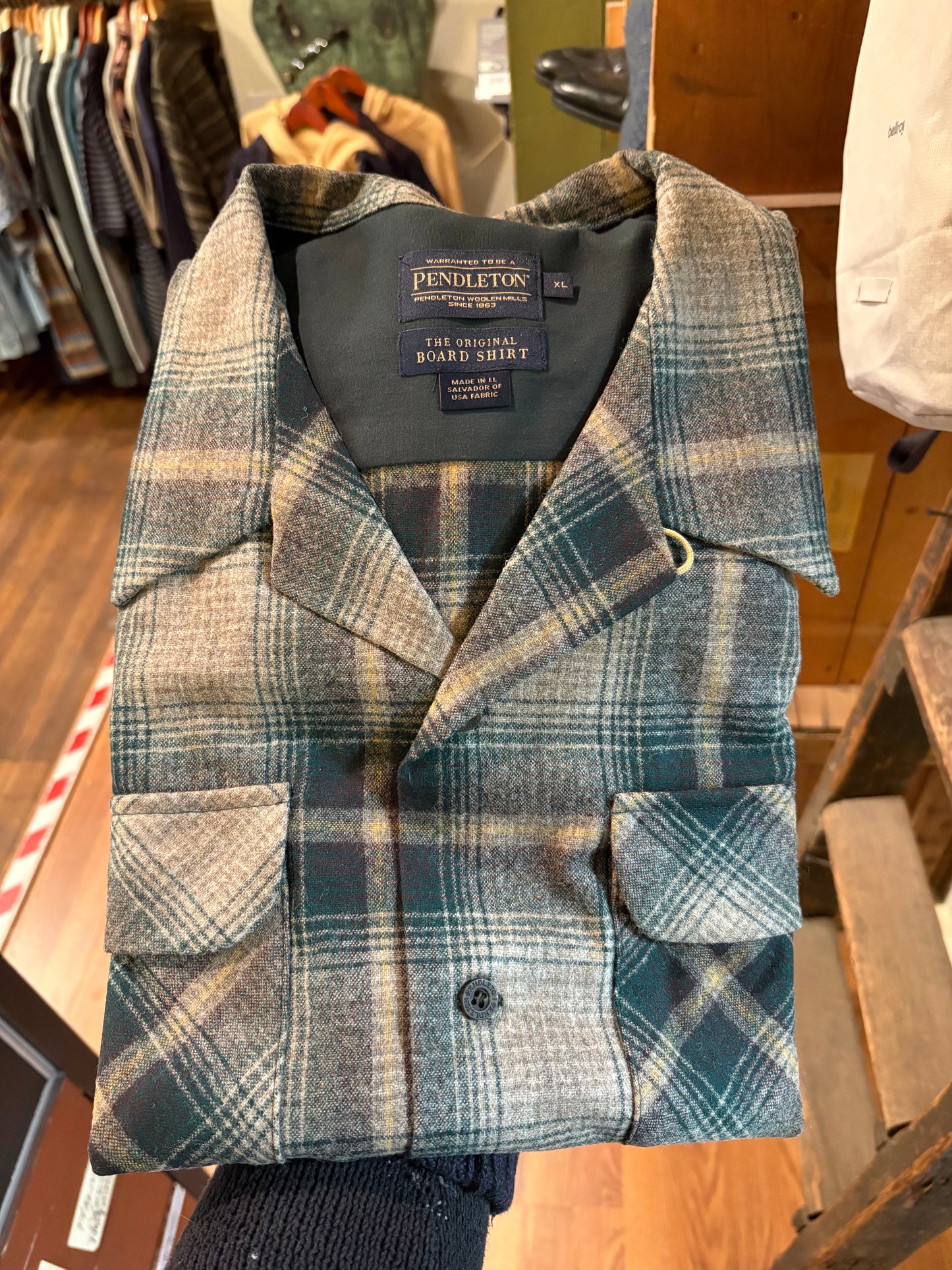 Plaid jacket with Pendleton label on a wooden surface