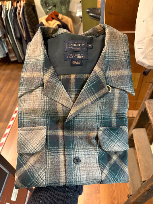 Plaid jacket with Pendleton label on a wooden surface
