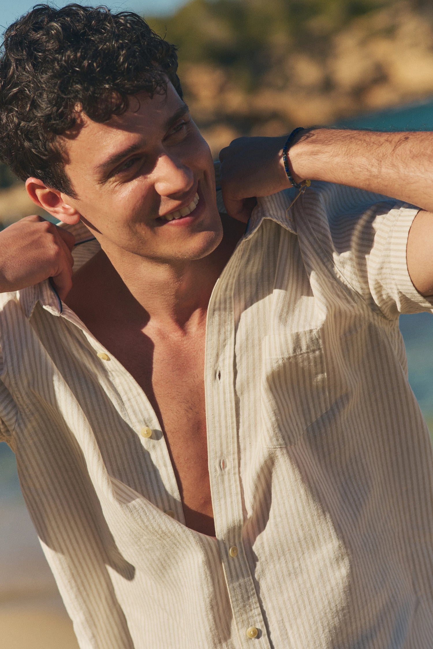 Man wearing a light-colored shirt on a beach