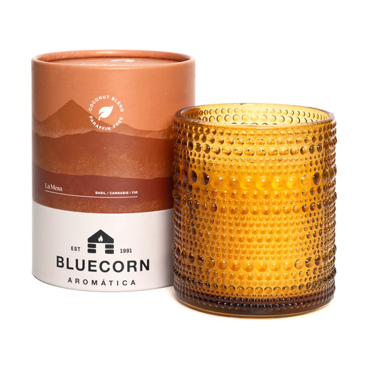 Yellow textured candle with 'Bluecorn Aromatica' packaging on a white background