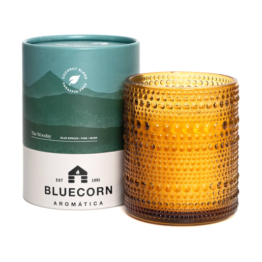 Yellow textured candle with Bluecorn Aromatica packaging on a white background