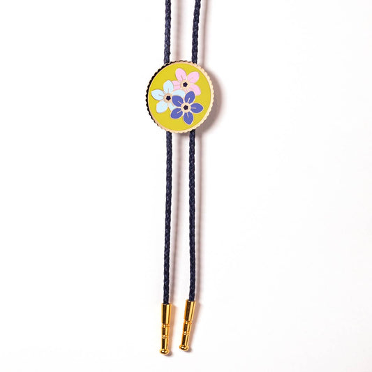 Bolo tie with floral design on a yellow background