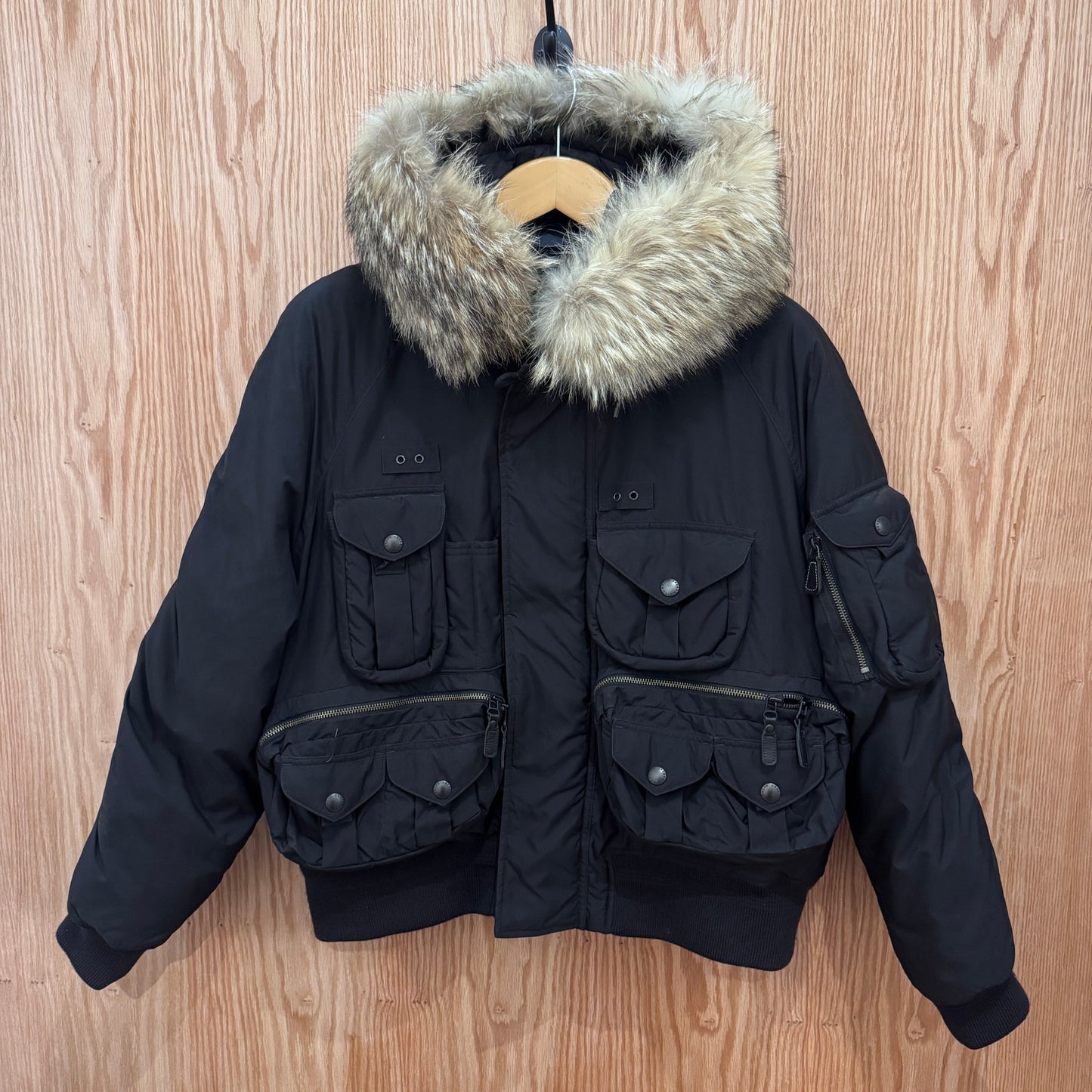 Black winter jacket with fur hood on a wooden background