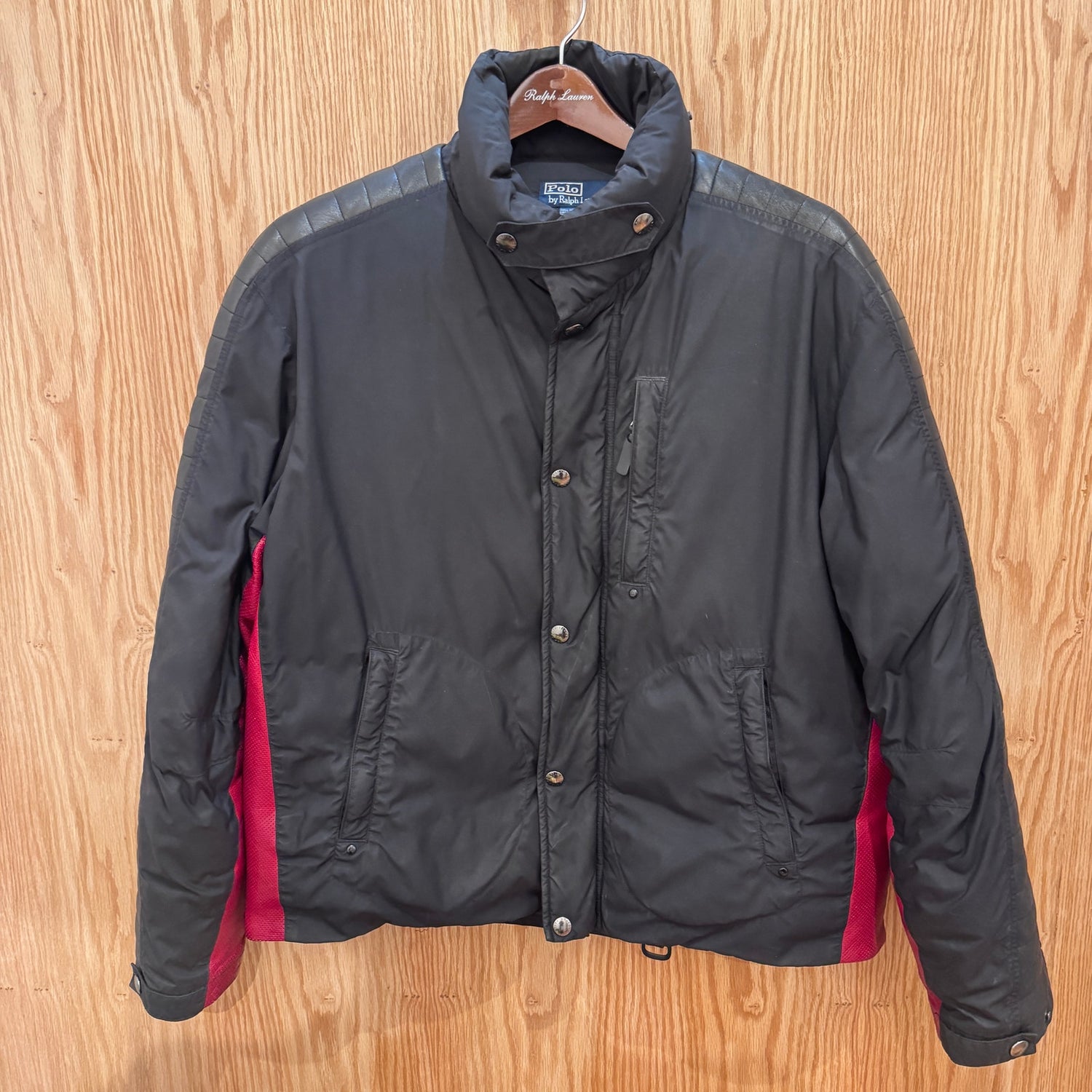 Black jacket with red lining on a wooden surface