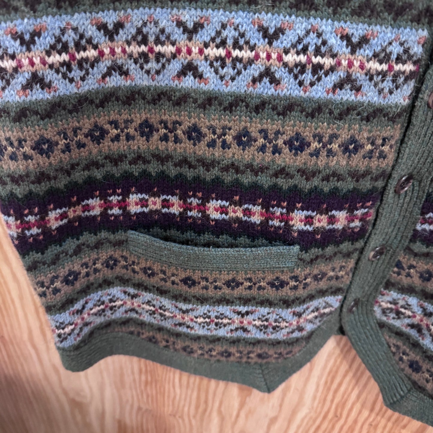 Close-up of a knitted garment with a pattern on a wooden surface