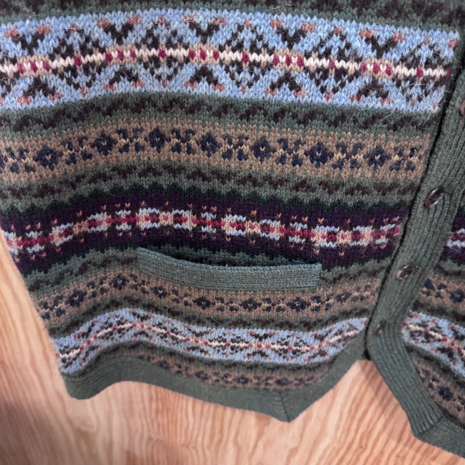 Close-up of a knitted garment with a pattern on a wooden surface