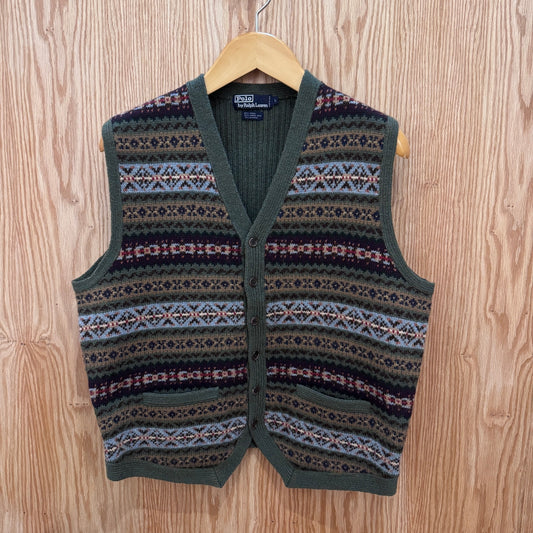 Patterned vest on a wooden hanger against a wooden background