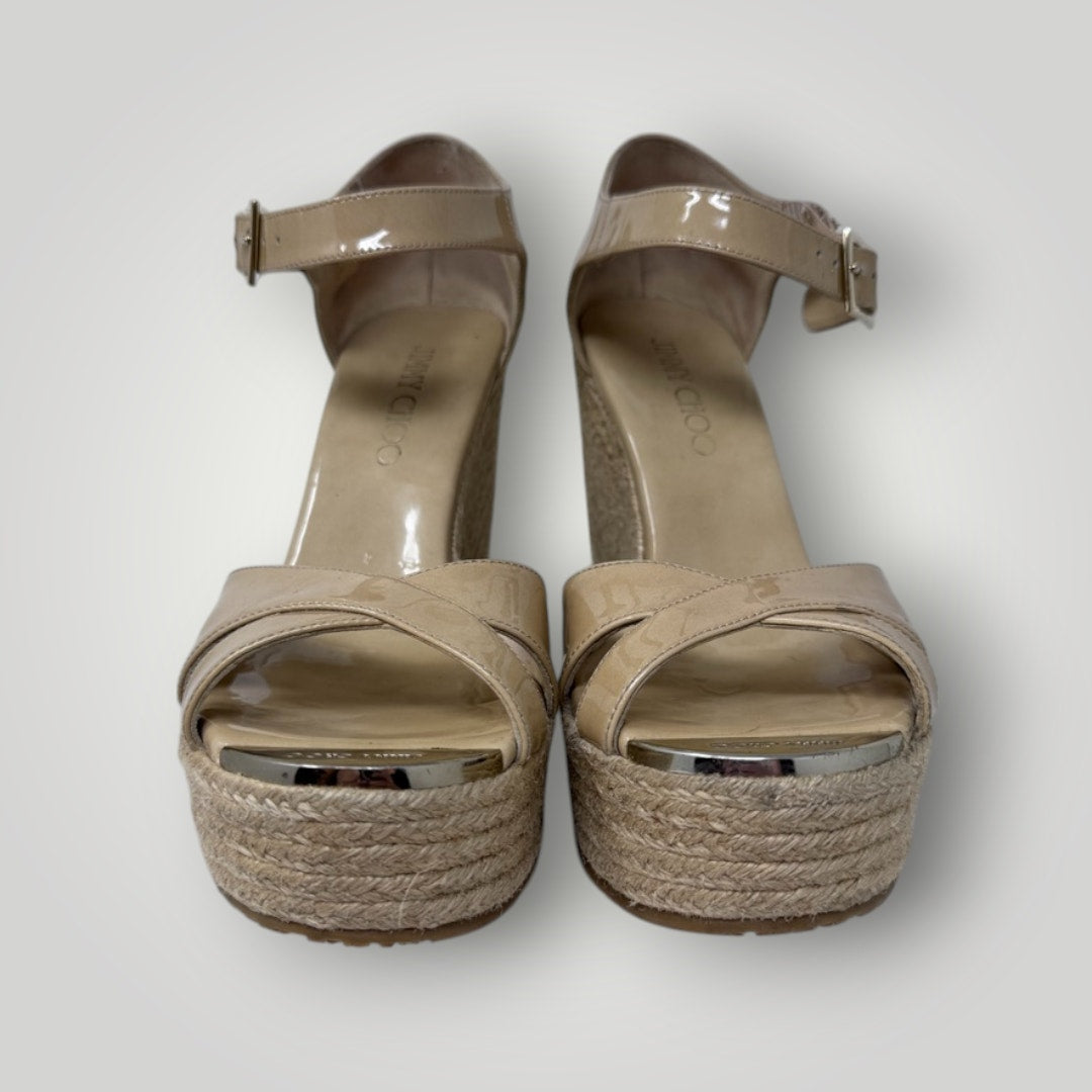 Pair of beige high-heeled sandals with woven sole on a white background