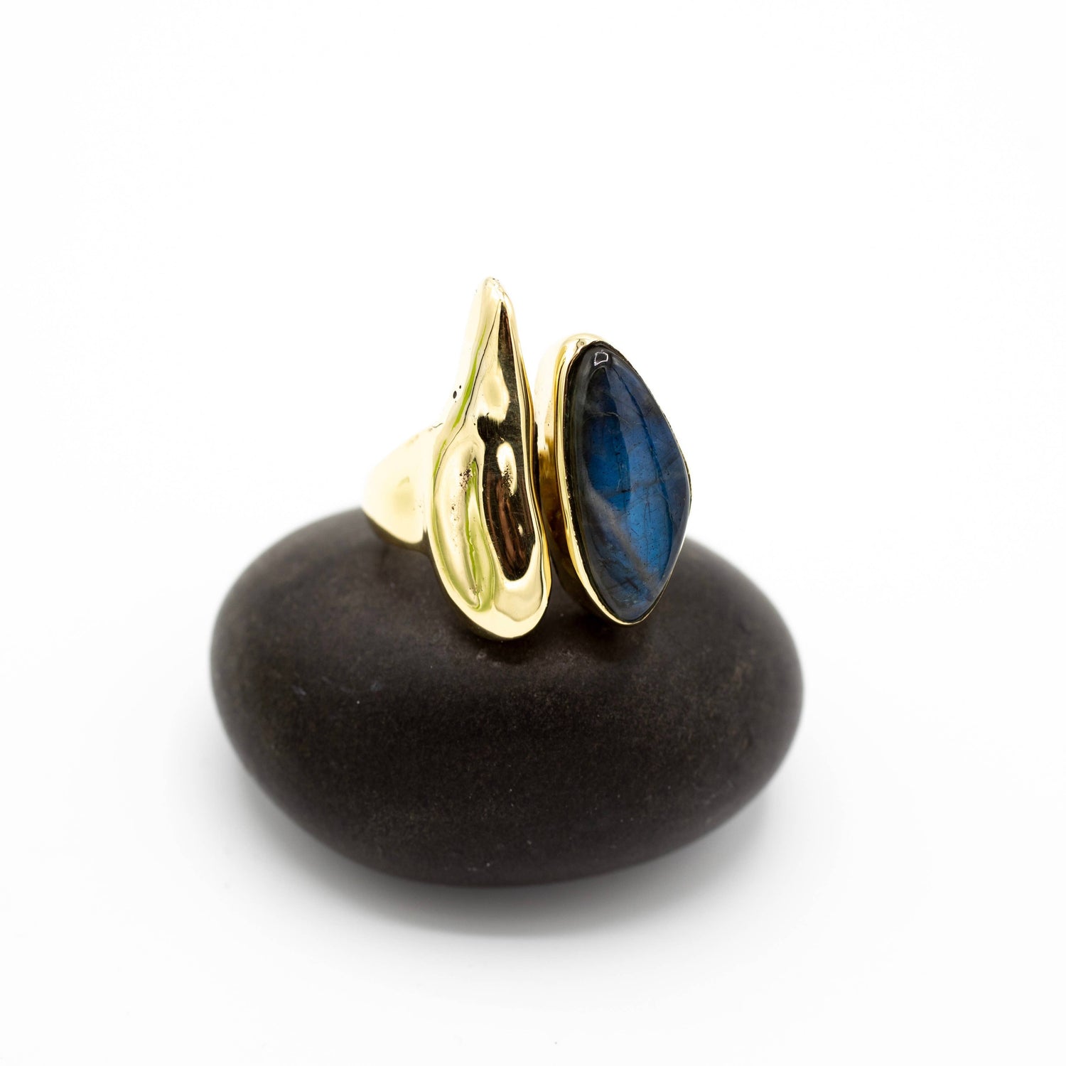 Gold and blue ring on a dark stone surface with a white background