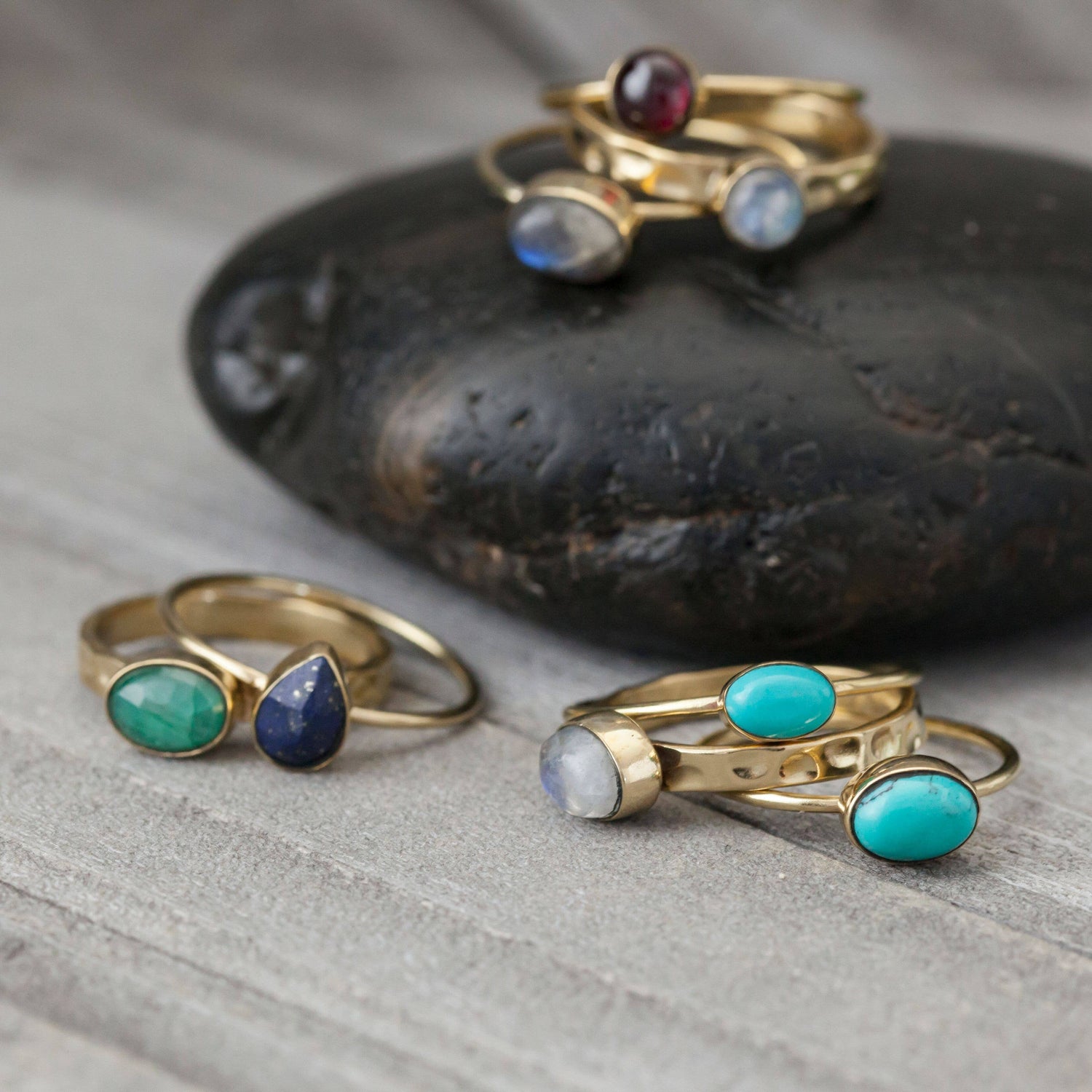 Gold rings with gemstones on a stone surface