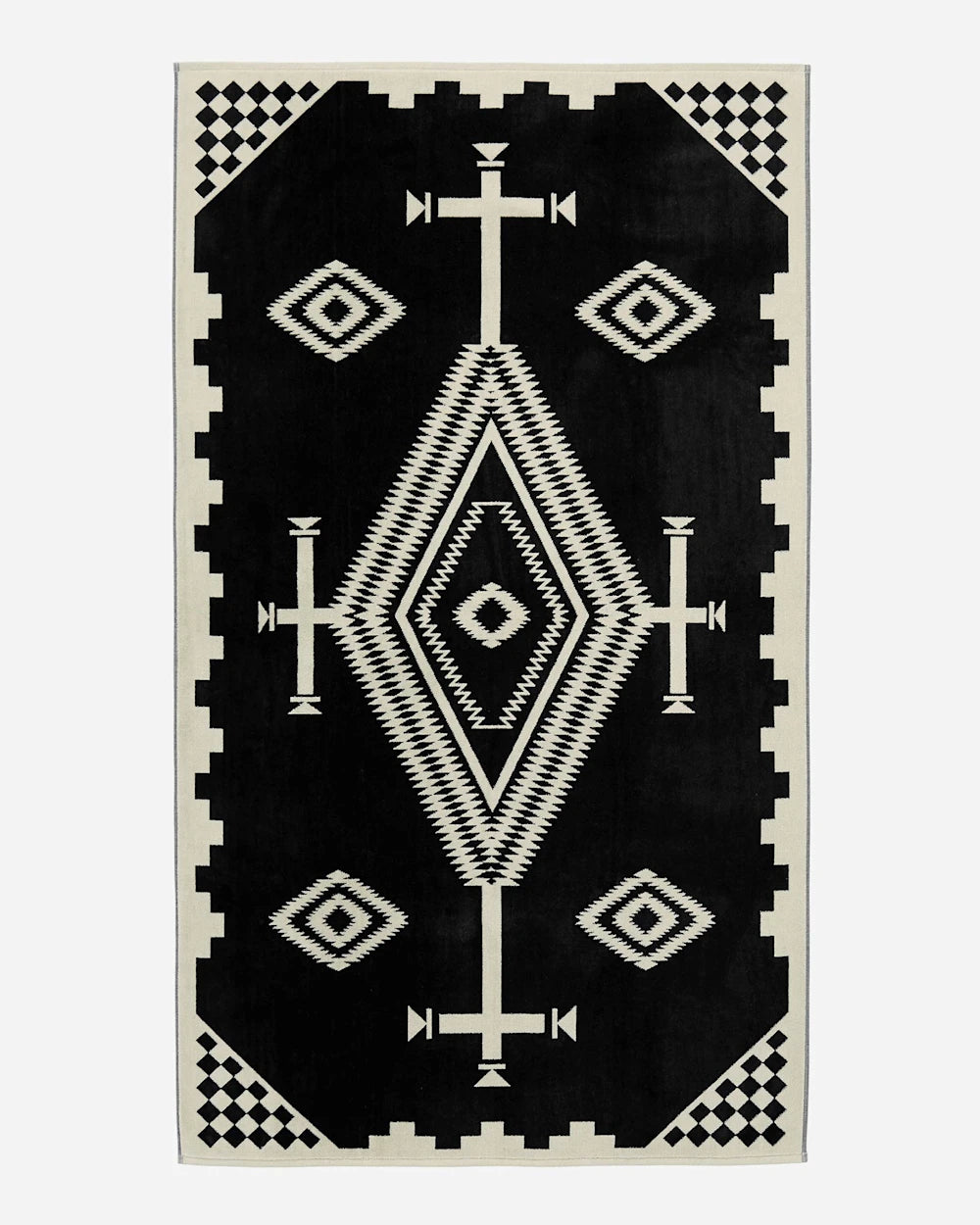Black rug with white geometric pattern on a plain background