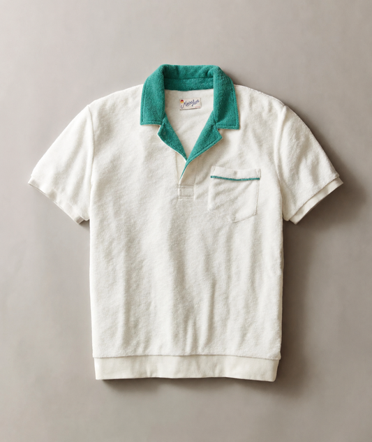 White polo shirt with green collar on a gray background