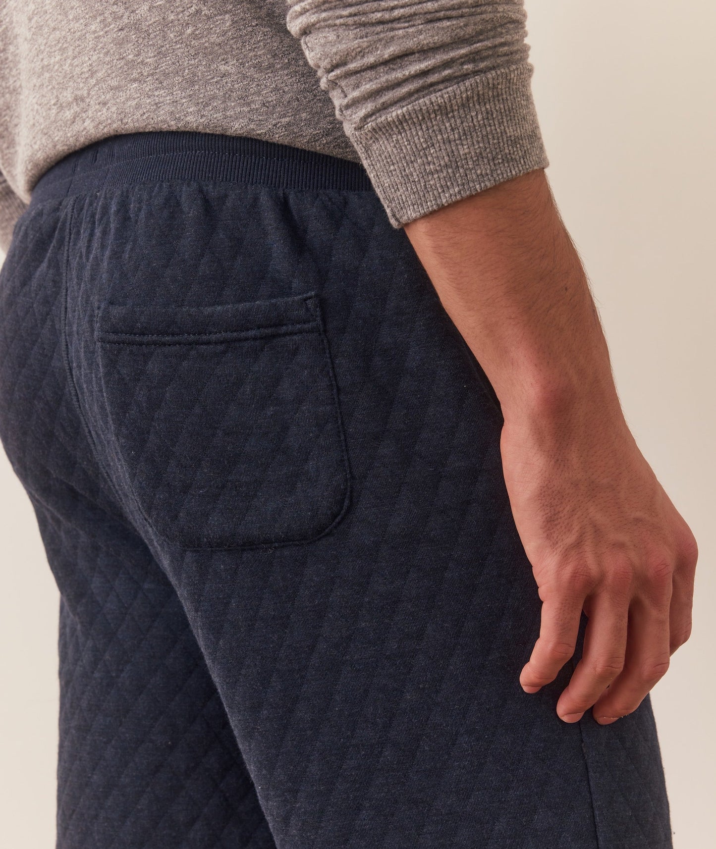 Navy quilted pants worn by a person on a neutral background