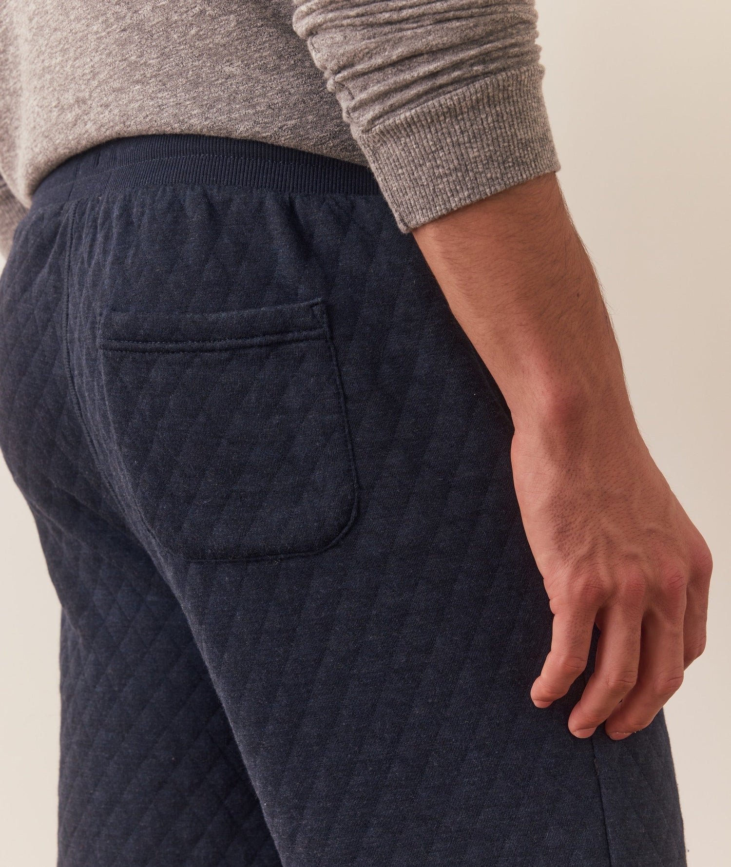 Navy quilted pants worn by a person on a neutral background