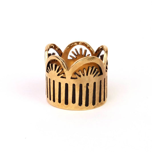 Gold ring with intricate design on a white background