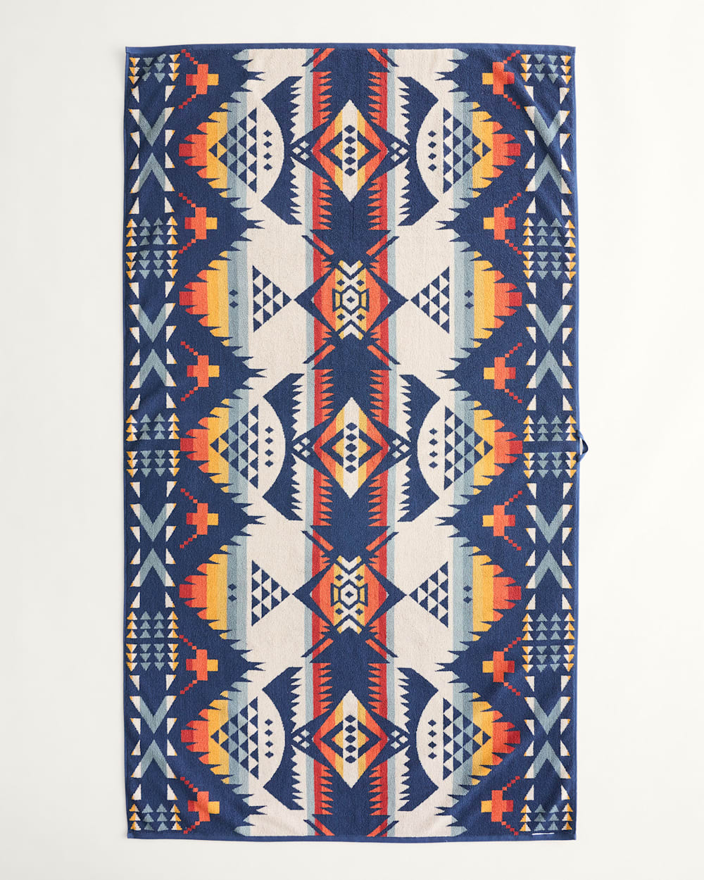 Geometric patterned rug with blue, orange, and white colors on a white background