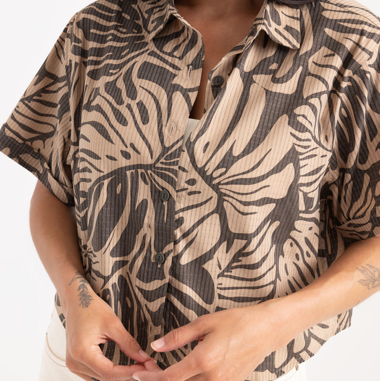 Person wearing a patterned shirt with a neutral background