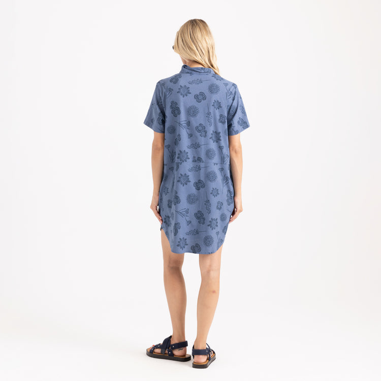 Woman wearing a blue patterned dress on a white background