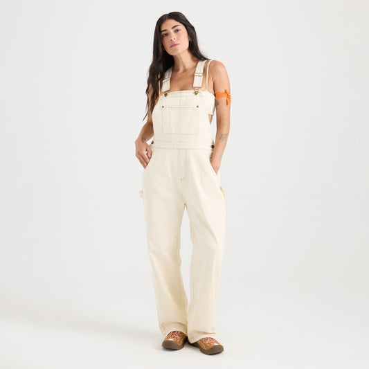 Woman wearing beige overalls on a white background