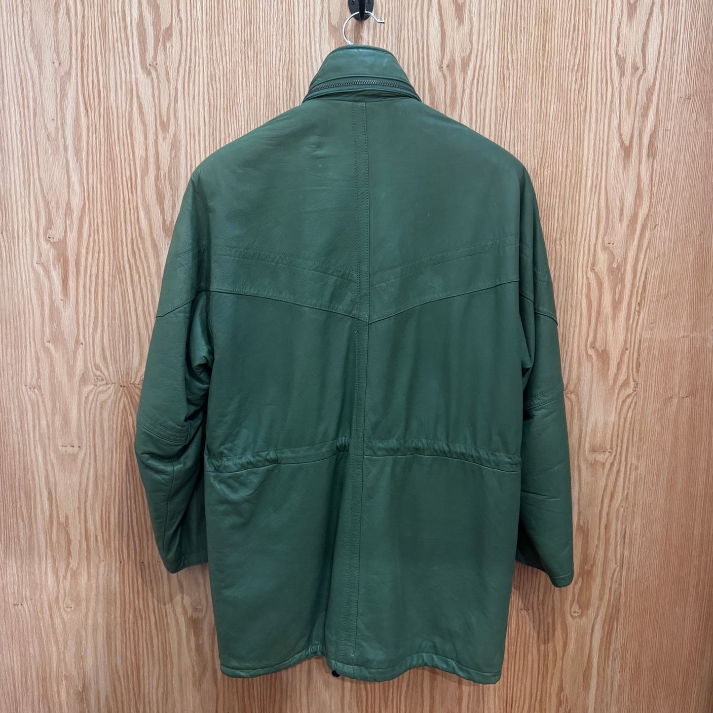 Green jacket on a hanger against a wooden background