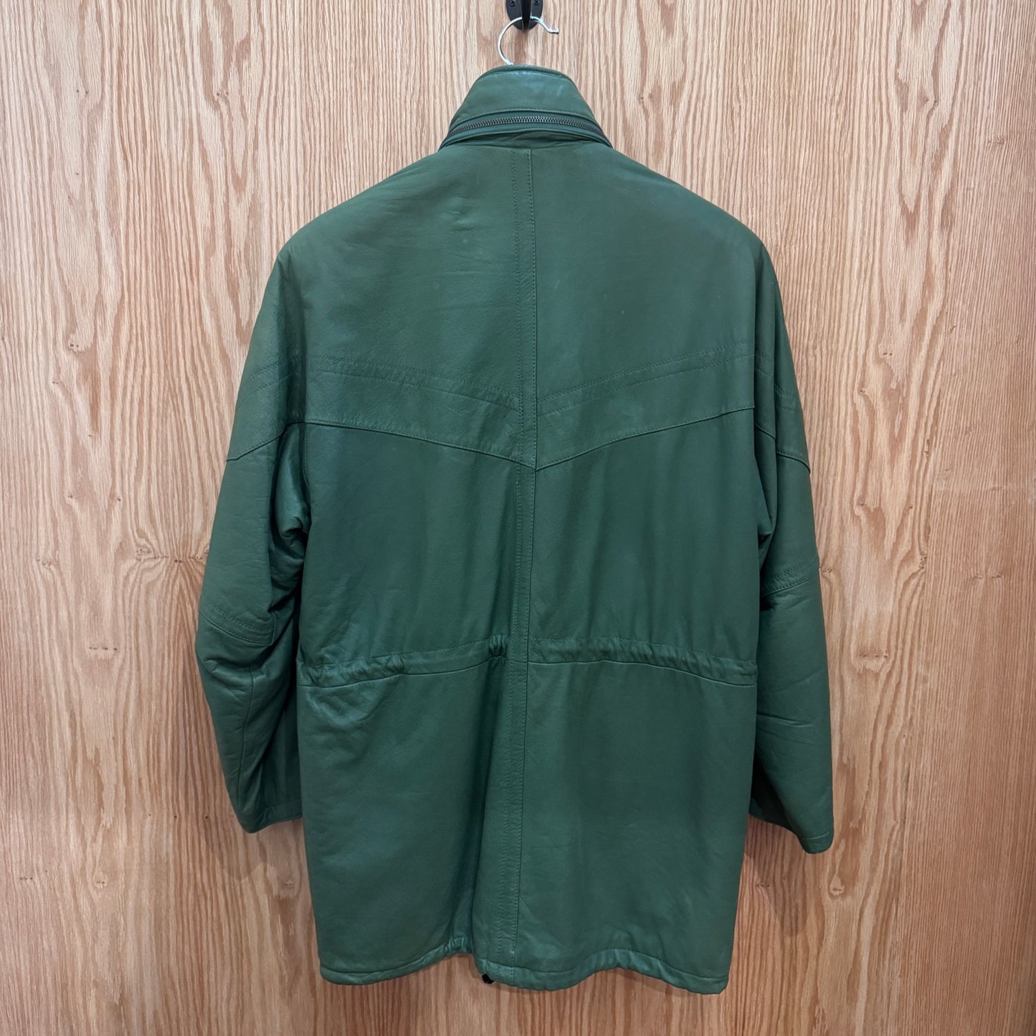 Green jacket on a hanger against a wooden background